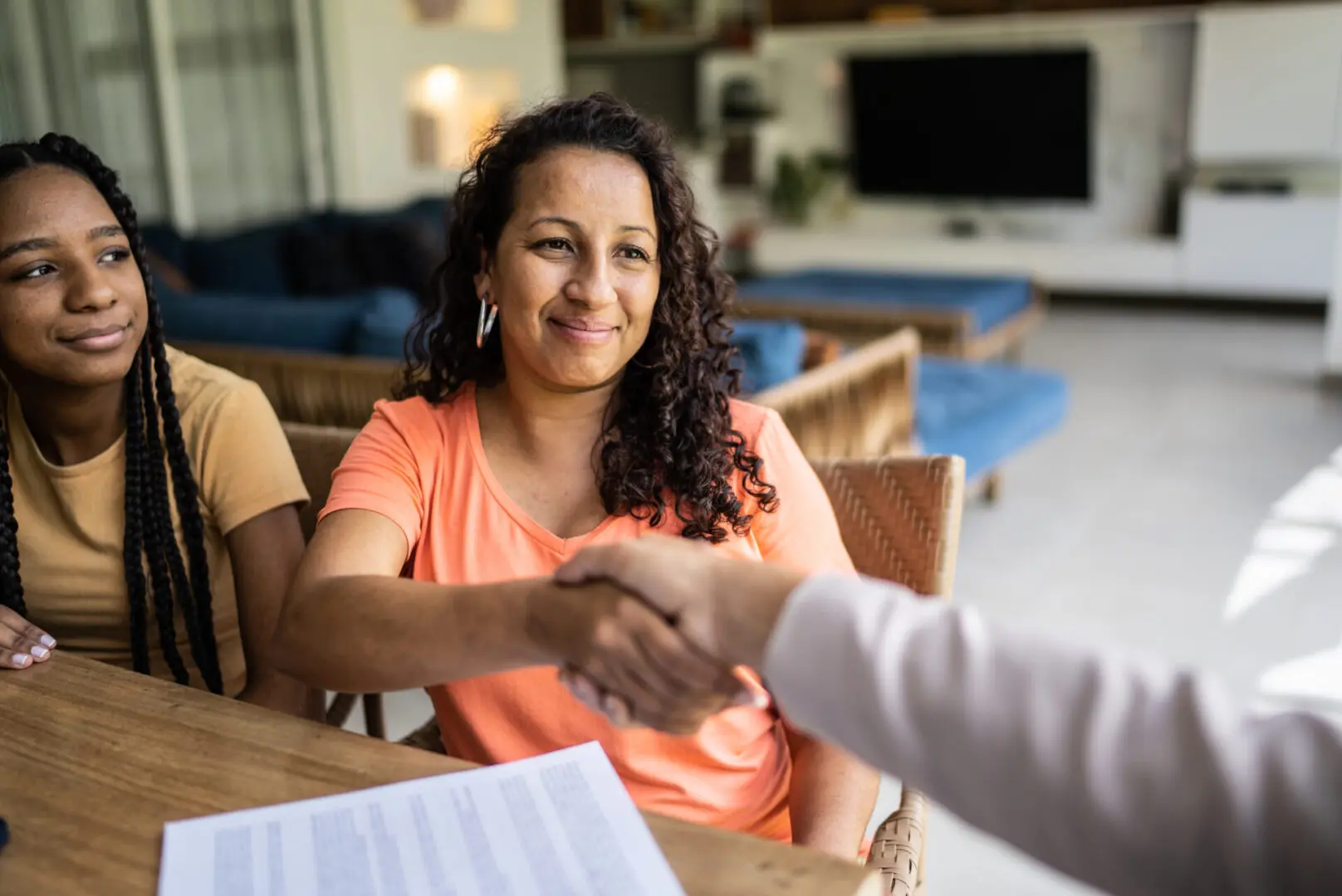 Smiling woman shaking hands after signing documents
