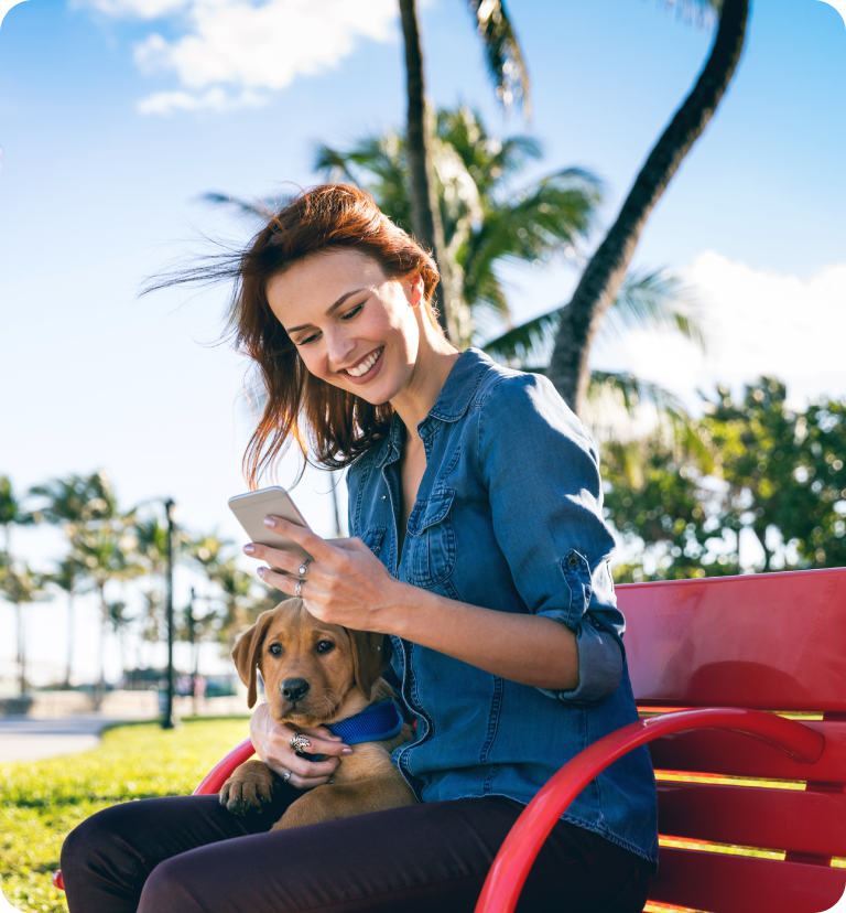 Woman smiling with puppy and smartphone