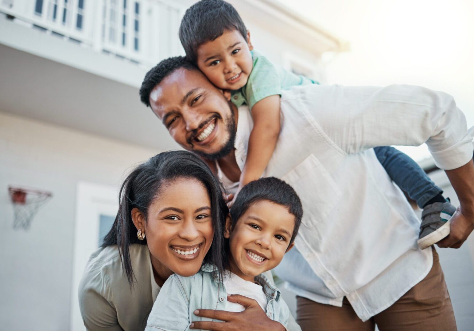 Smiling family of four outside home